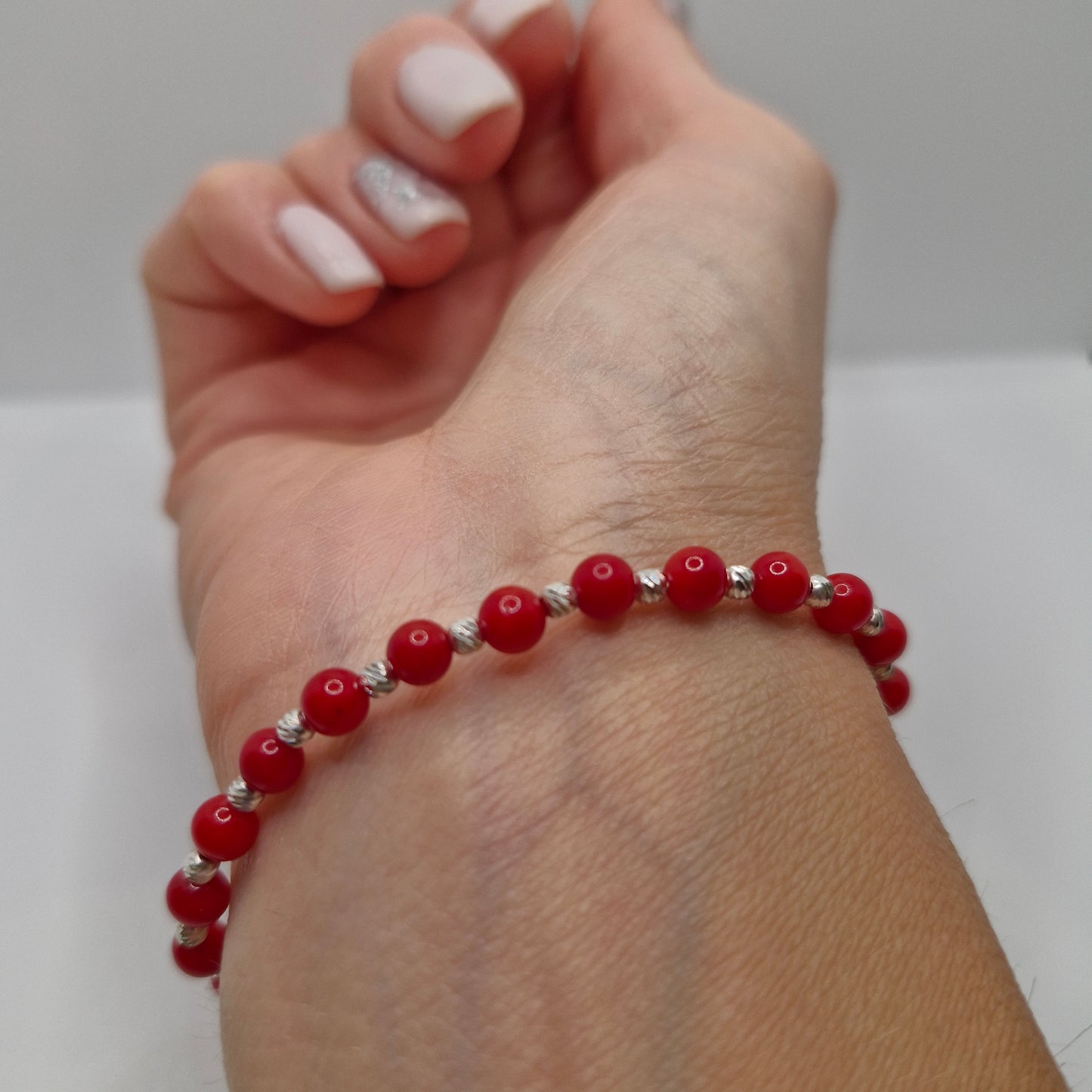4mm Coral dyed stretch bracelet with round gemstone beads and 2mm corrugated sterling silver accents.