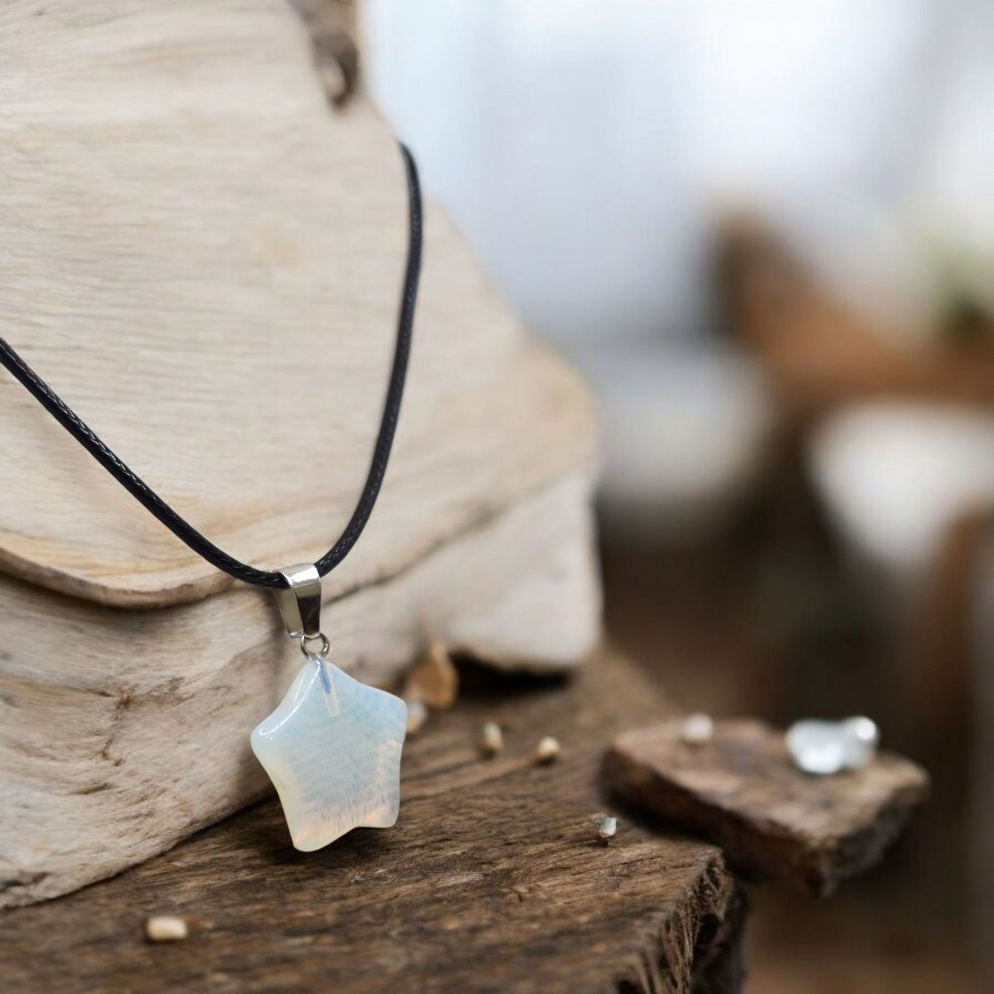 Opalite star necklace displayed on black waxed cord, elegant unisex crystal jewellery piece