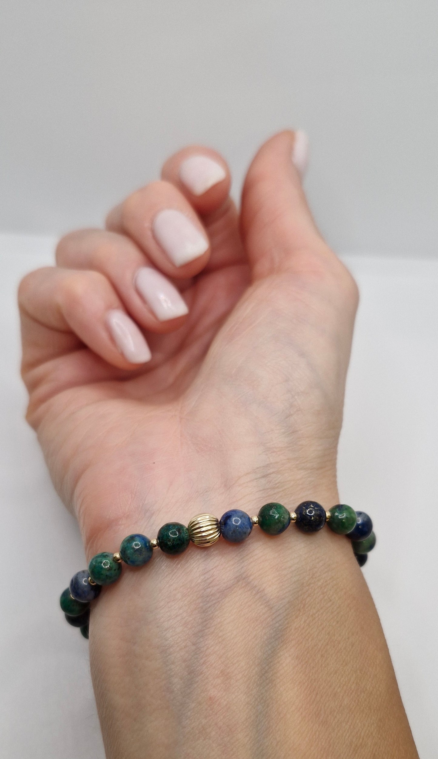 Chrysocolla bracelet with gold-filled accents worn on wrist, symbolizing calm, balance, and heart-centered energy.