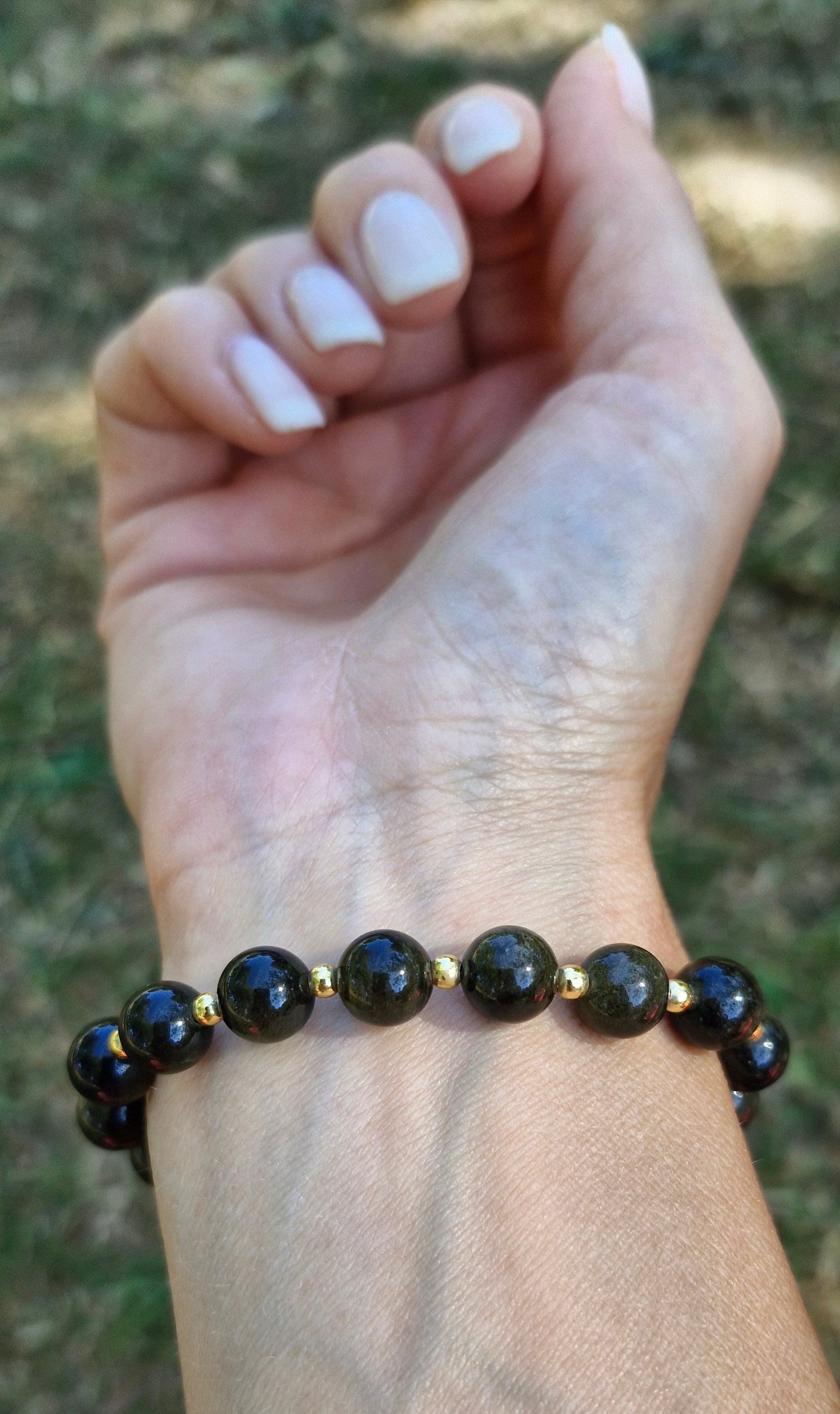 Golden Obsidian stretch bracelet with 8mm gemstones and 3mm 18K gold plated beads, worn on the wrist.