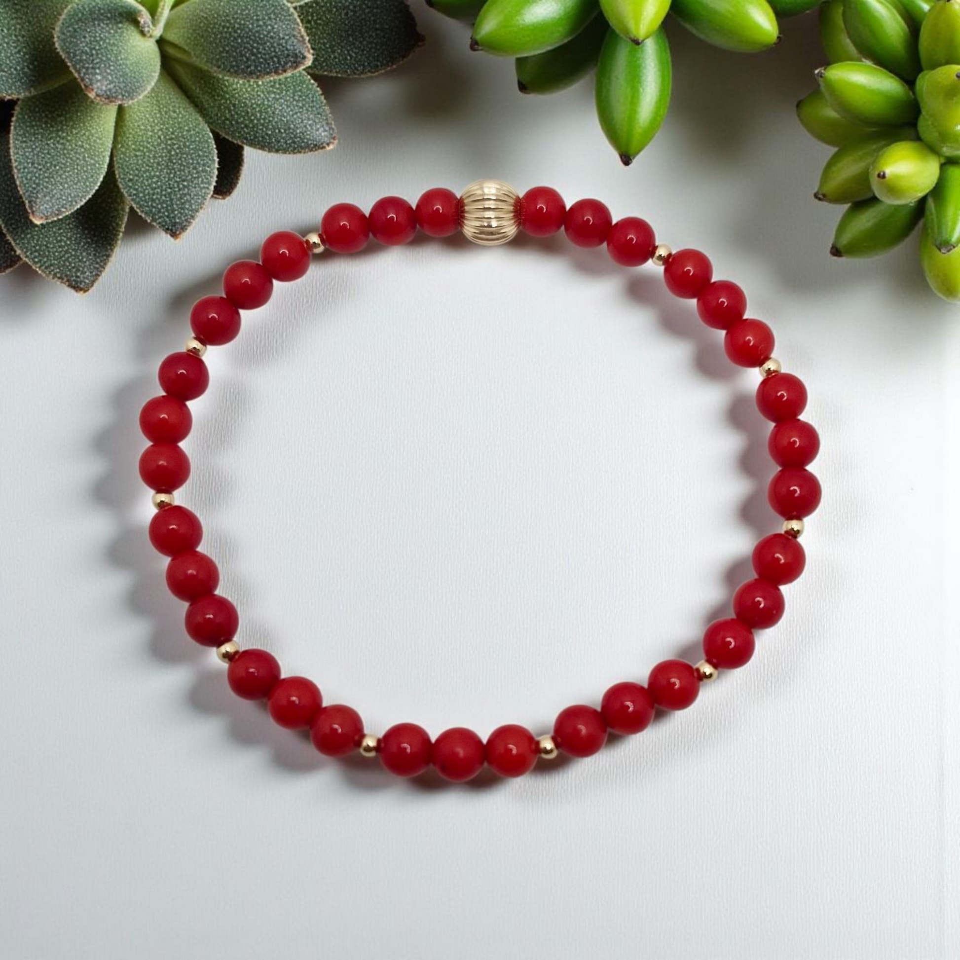 Handmade red Bamboo Coral stretch bracelet featuring 4mm smooth coral beads and 2mm gold filled accent beads, offering a vibrant, elegant, and durable design.