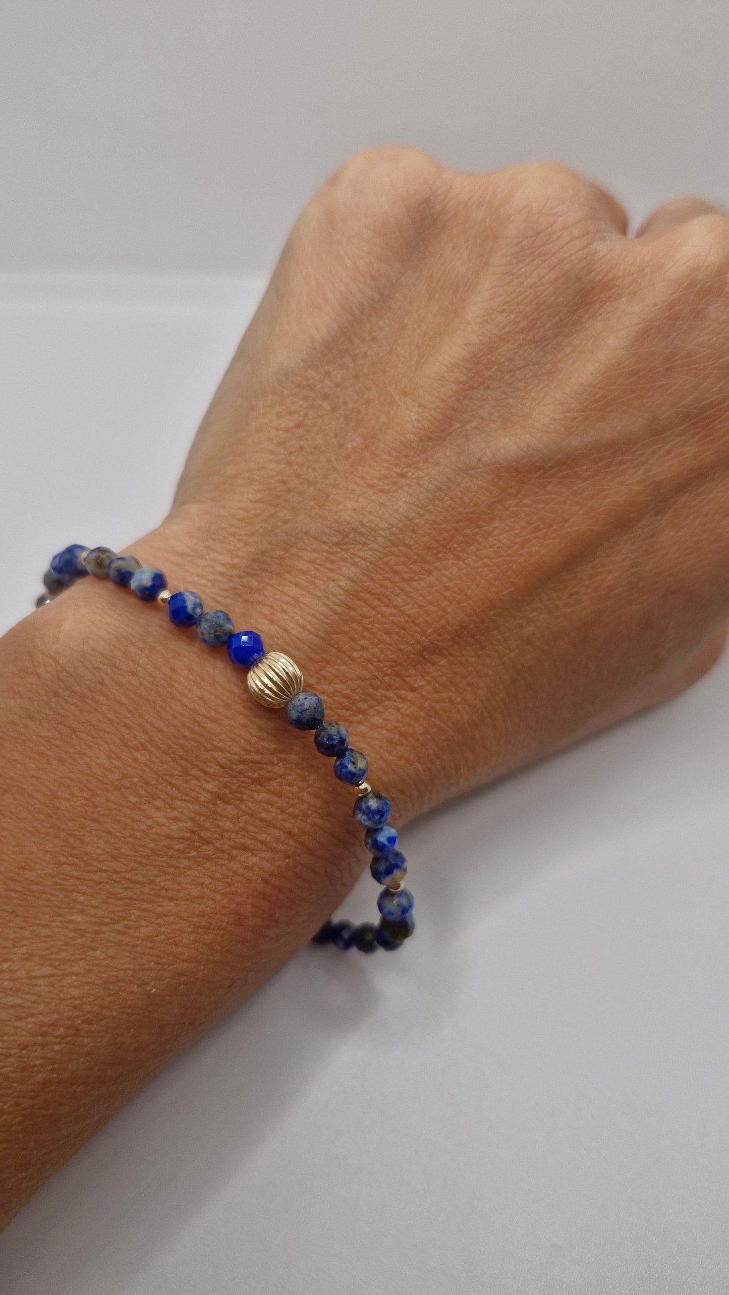 Handmade faceted Lapis Lazuli stretch bracelet with 2mm and 6mm gold filled beads, worn on wrist for everyday elegance