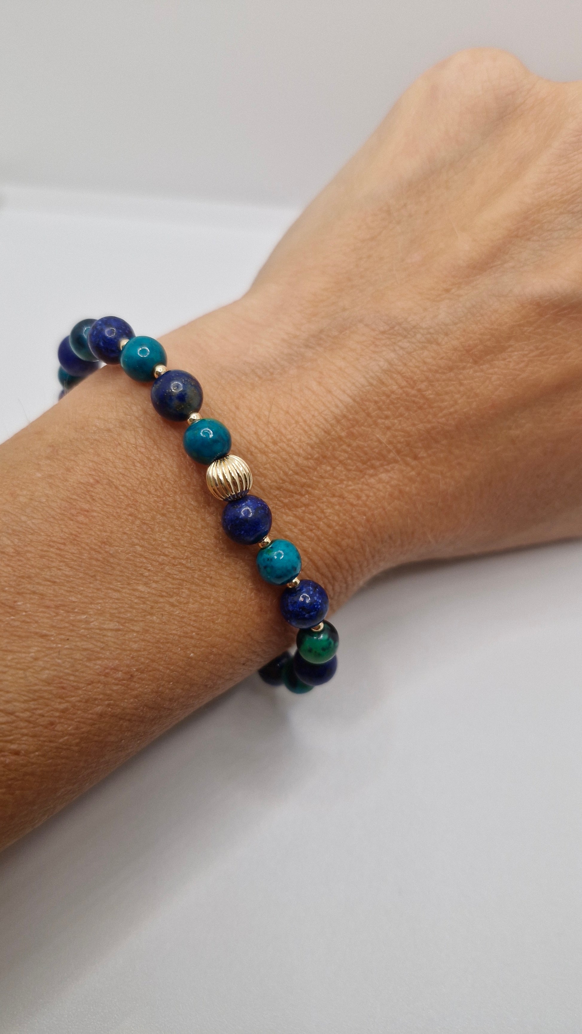 Wrist shot of a unisex gemstone bracelet featuring 6mm Lapis Lazuli, Chrysocolla, and 2mm & 6mm gold filled beads, perfect for daily wear