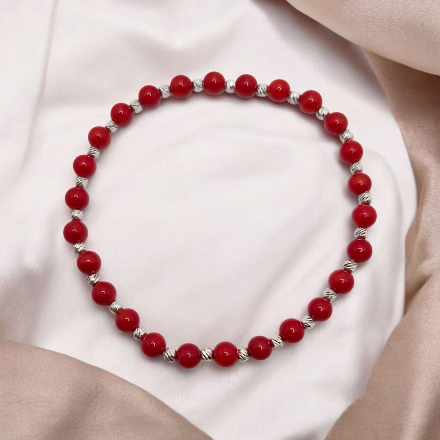 Red Coral dyed gemstone bracelet with faceted stretch design and sterling silver accents.