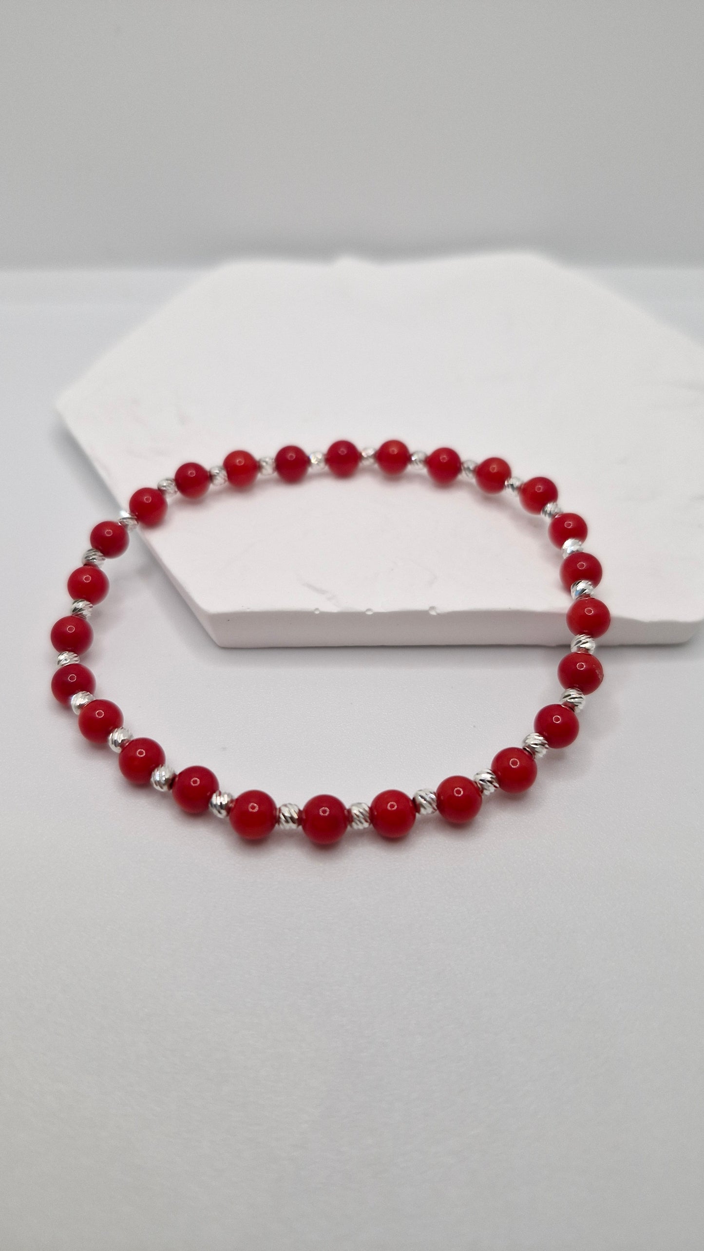 4mm Coral dyed stretch bracelet with round gemstone beads and 2mm corrugated sterling silver accents.