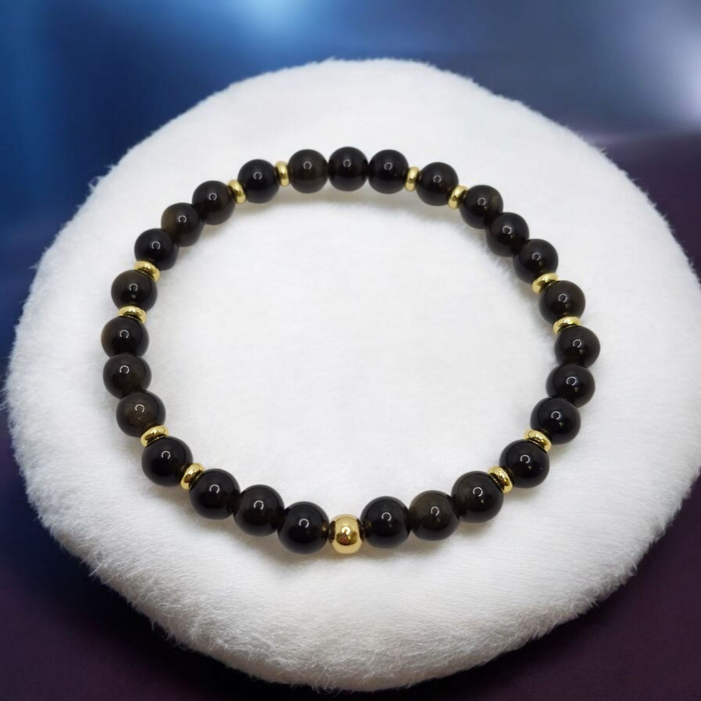 Elegant stretch bracelet featuring 6mm Obsidian beads with 4mm and 5mm gold-plated brass details