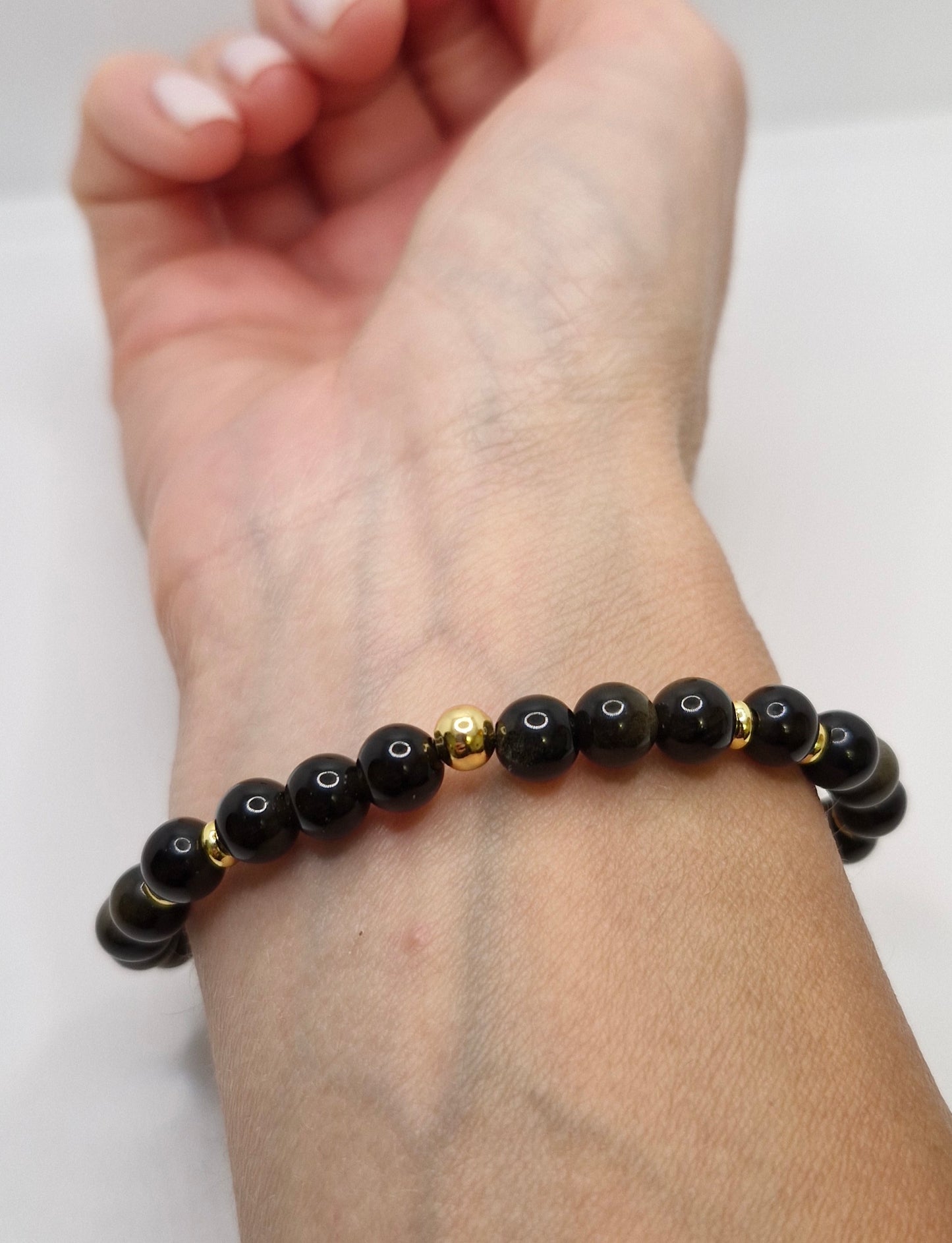 Protective and stylish Obsidian bracelet with shimmering gold-plated brass accents, perfect for gifting