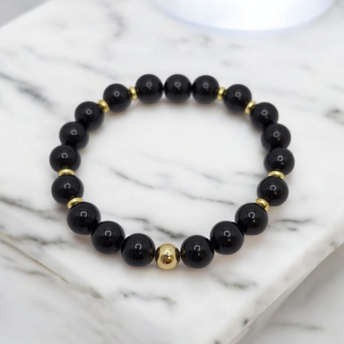 Elegant stretch bracelet featuring Grade A Black Tourmaline beads and a 6mm gold-plated round bead