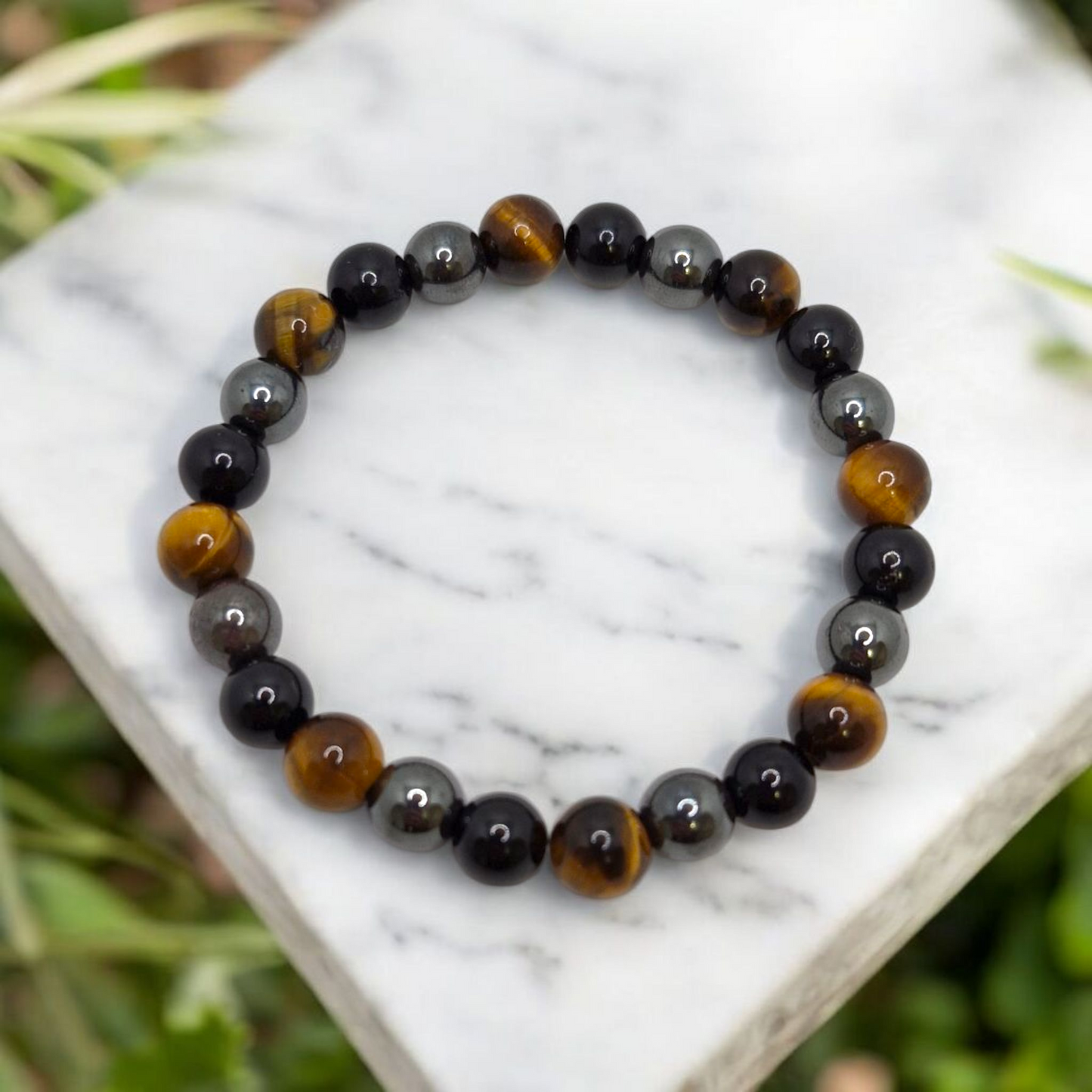 Triple Protection Bracelet featuring 8mm Hematite, Black Tourmaline, and Tiger’s Eye gemstones on stretch cord.