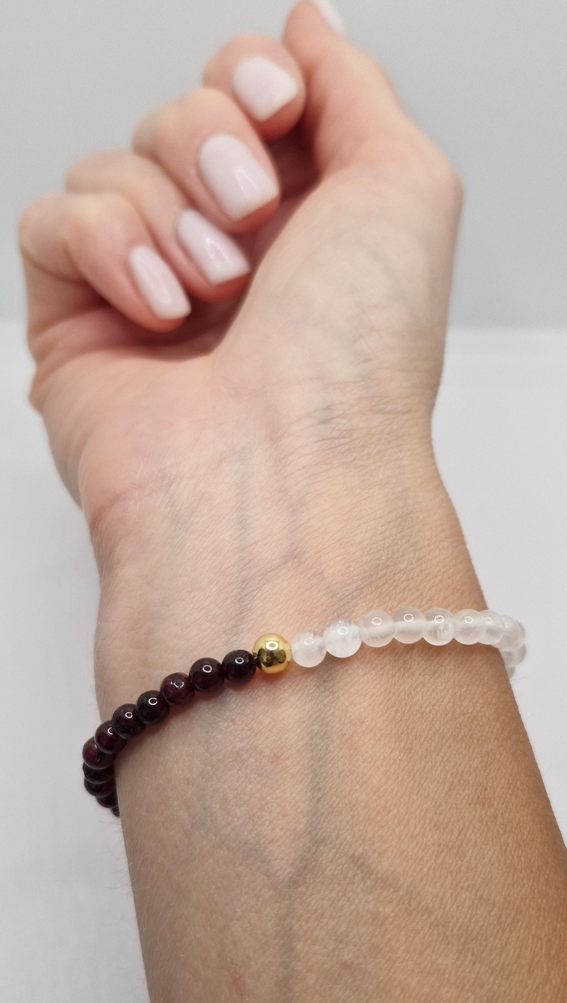 Hand wearing a bracelet with a white background