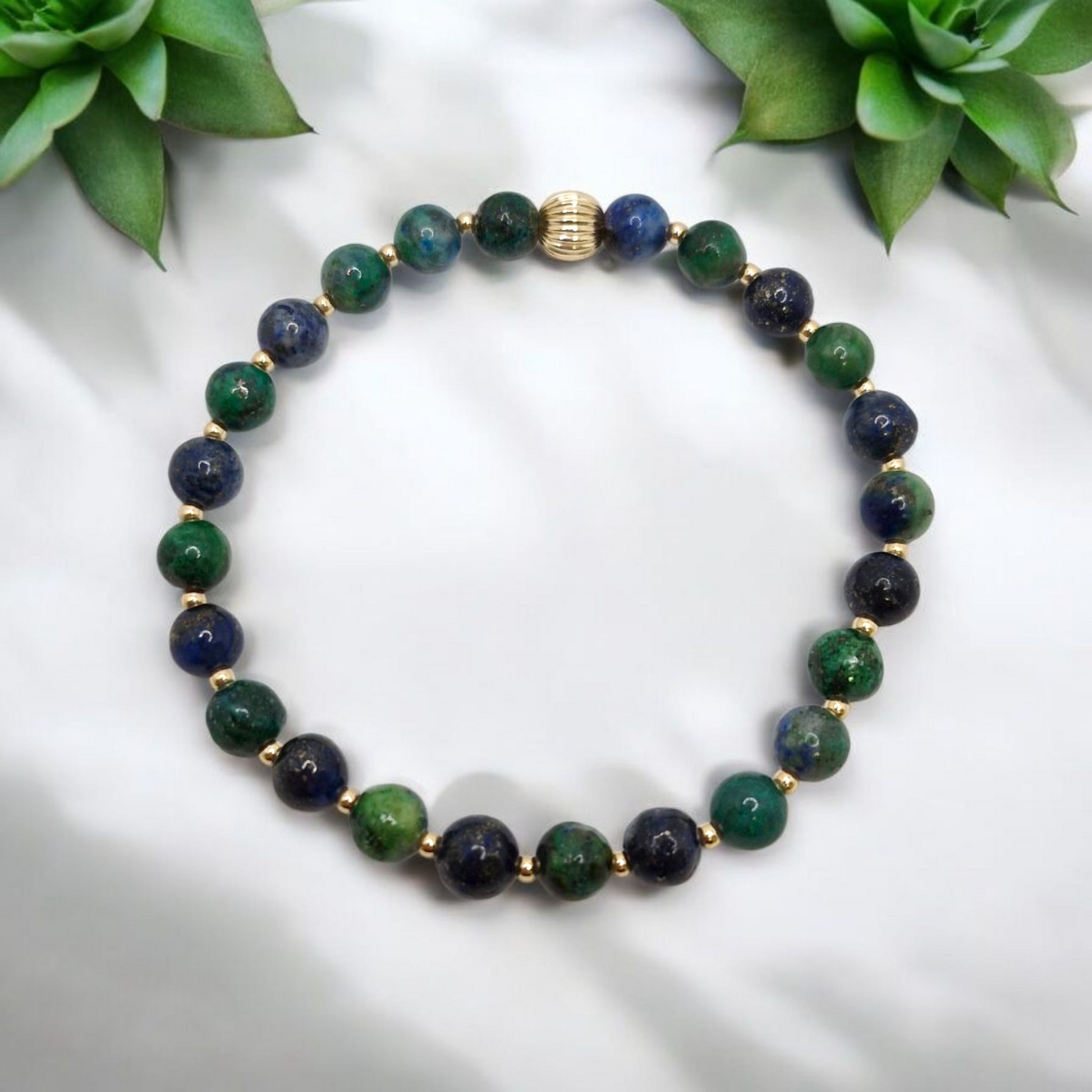 Close-up of Chrysocolla beads showing natural color variations and gold-filled corrugated accent bead with polished finish.