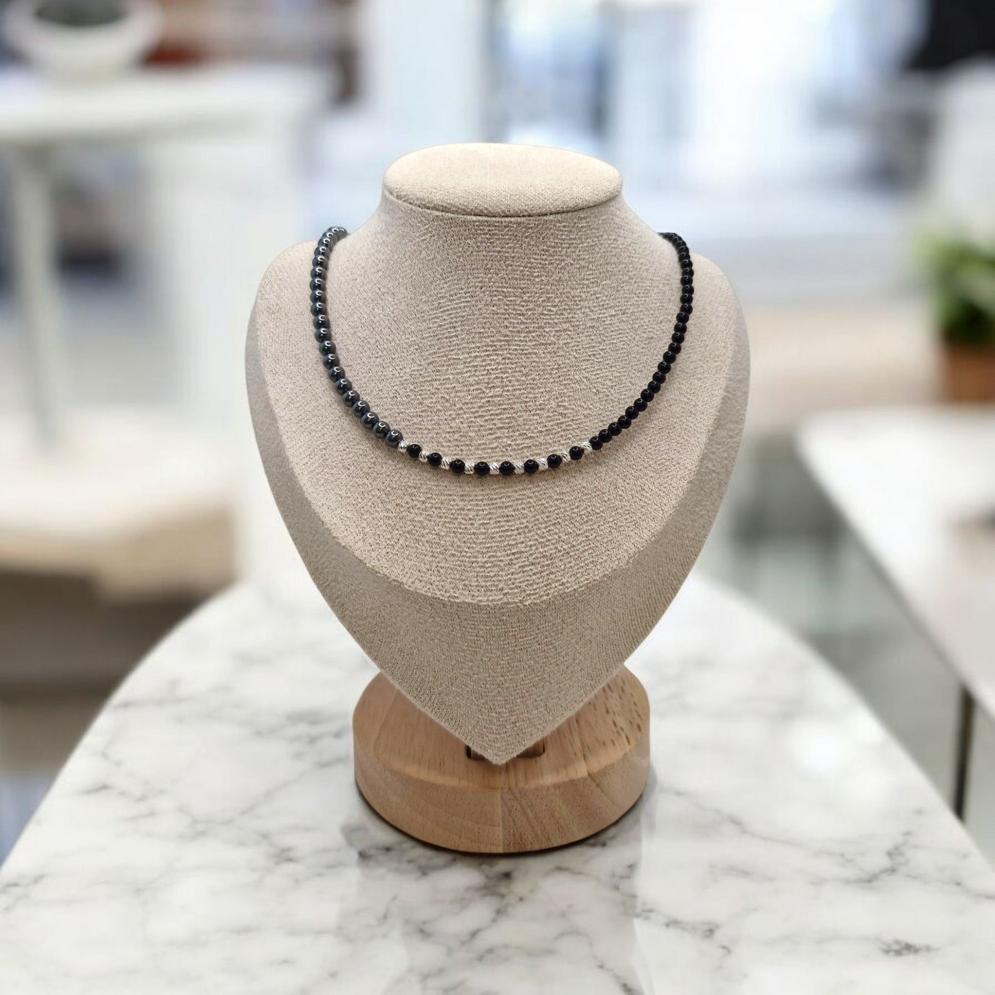 Necklace on a mannequin bust with a blurred indoor background