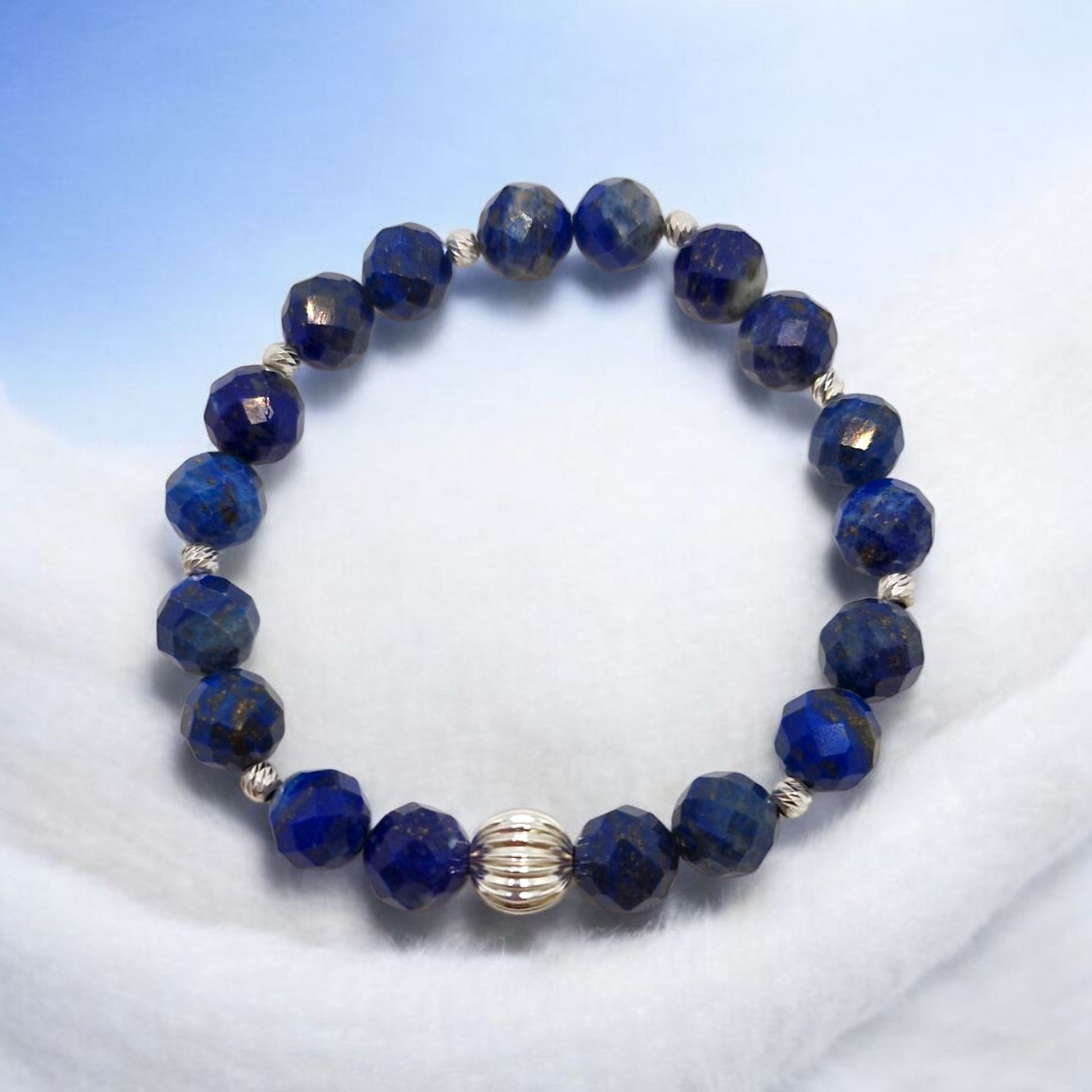 Blue beaded bracelet with a silver clasp on a white background