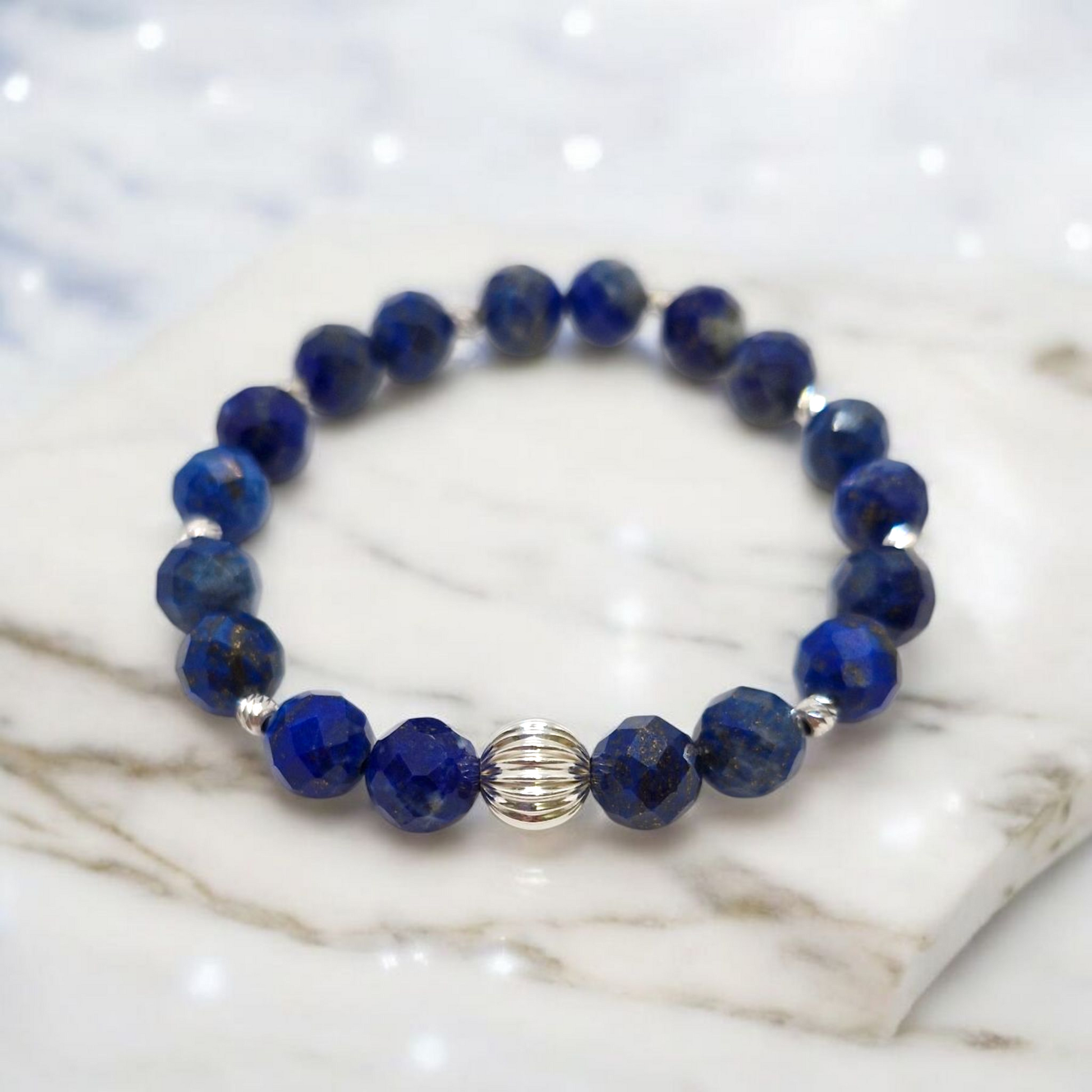 Blue beaded bracelet with silver accents on a marble surface