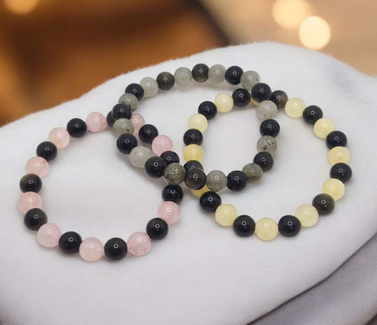 Set of beaded bracelets on a white surface with a blurred background