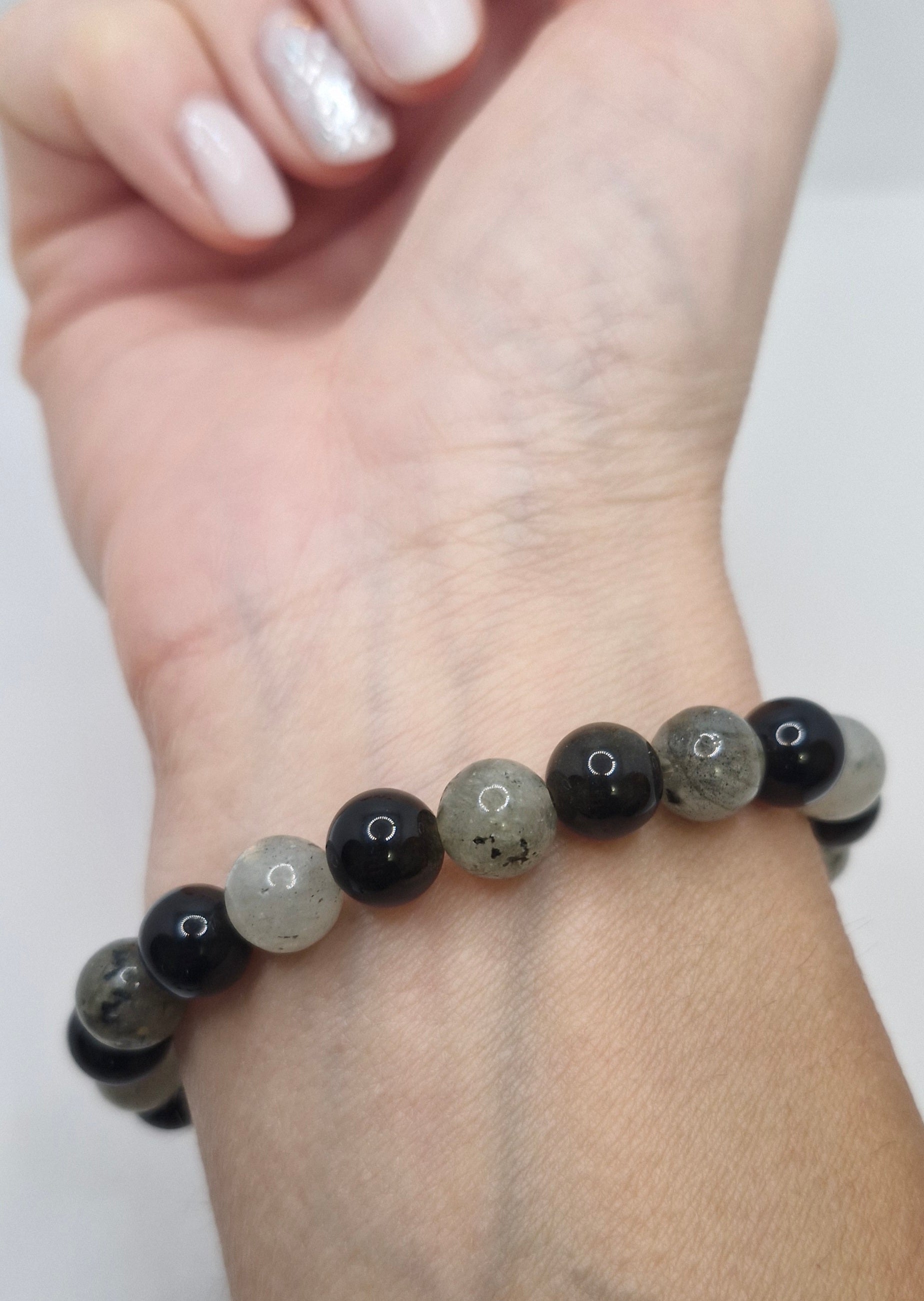 Beaded bracelet on a wrist with a plain background