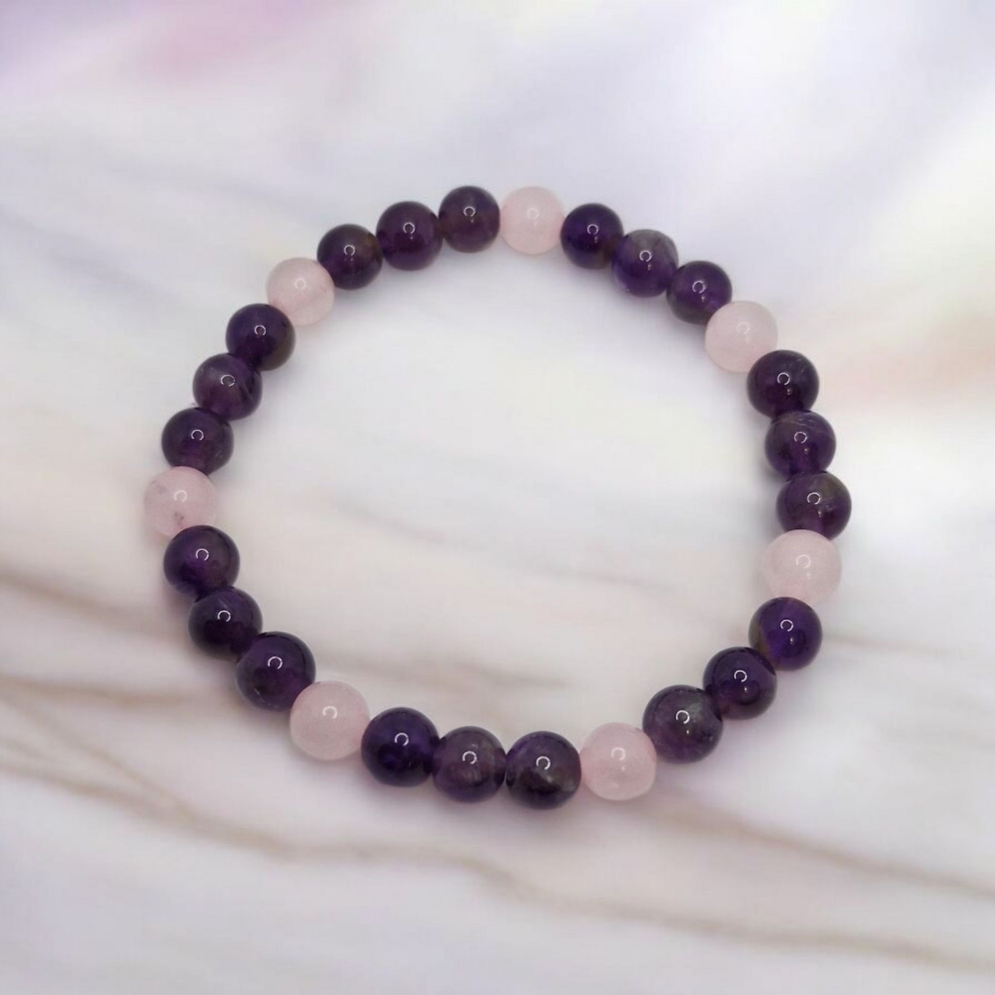 Beaded bracelet with purple and pink beads on a white background