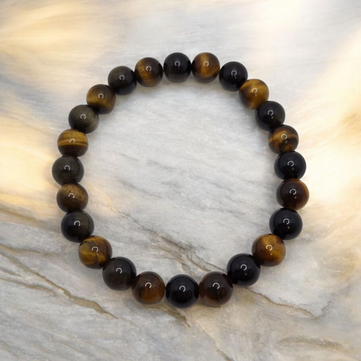 Beaded bracelet with black and brown beads on a marble surface