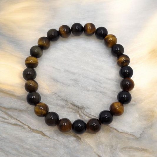Beaded bracelet with black and brown beads on a marble surface