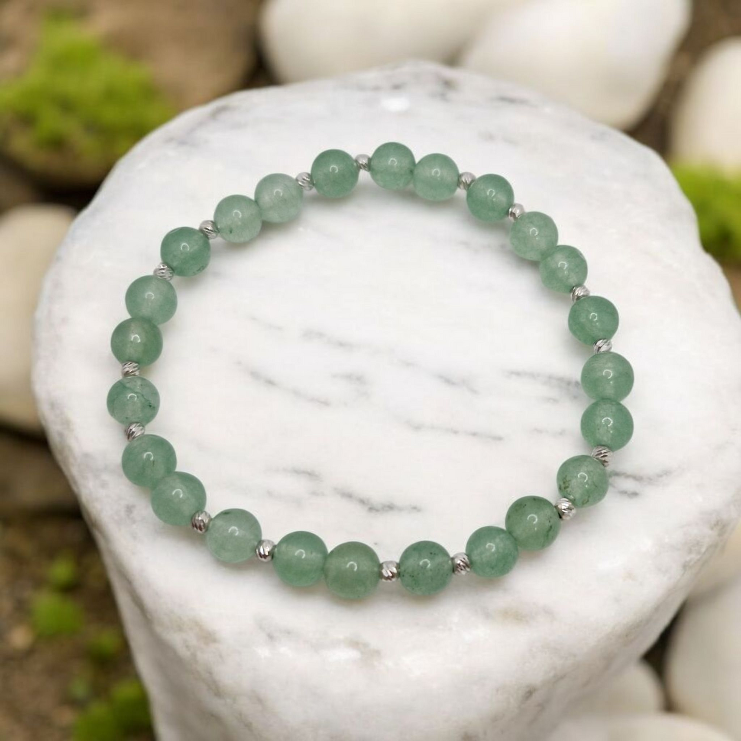 Green beaded bracelet on a white stone with a natural background