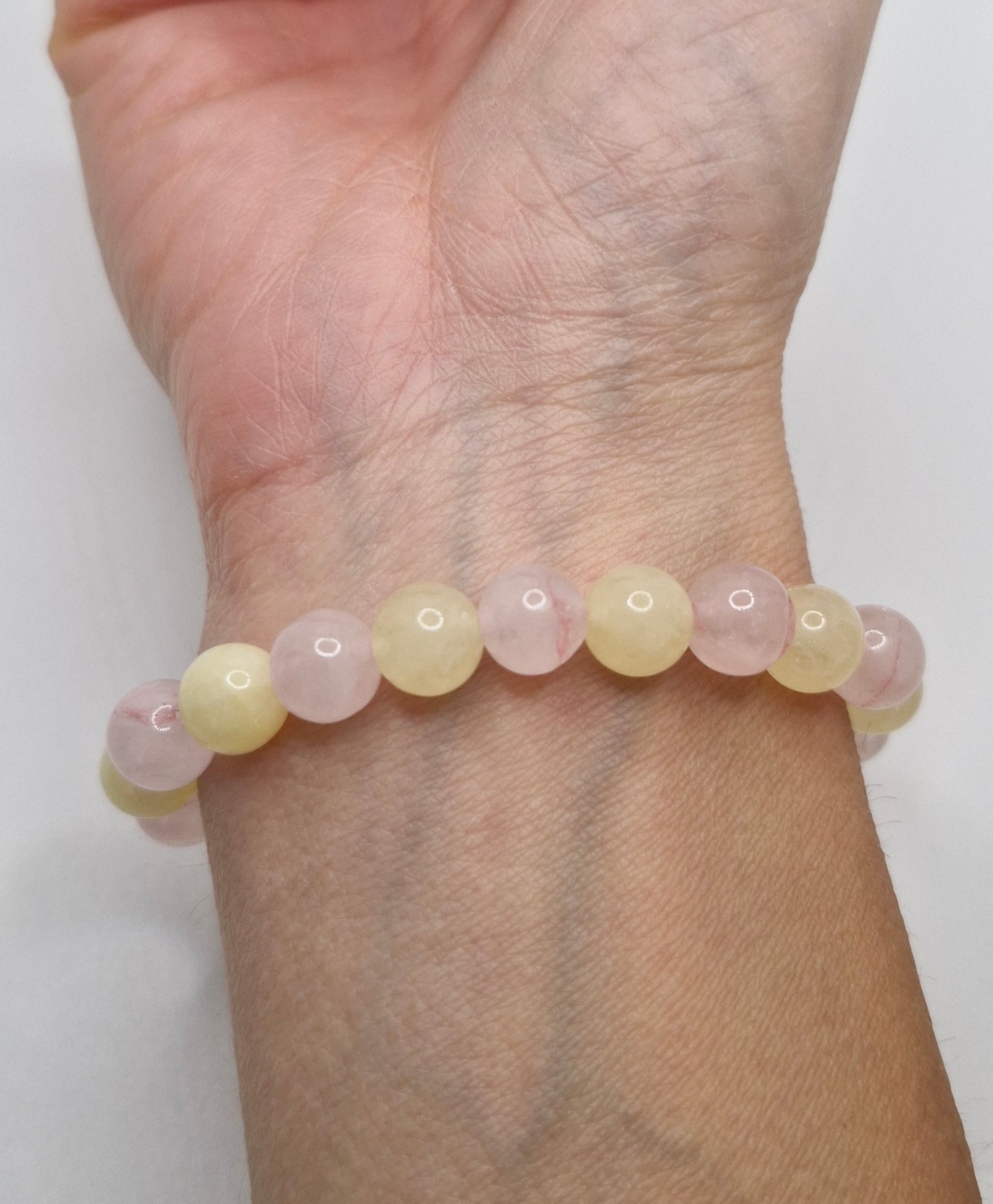 Beaded bracelet on a wrist with a plain background