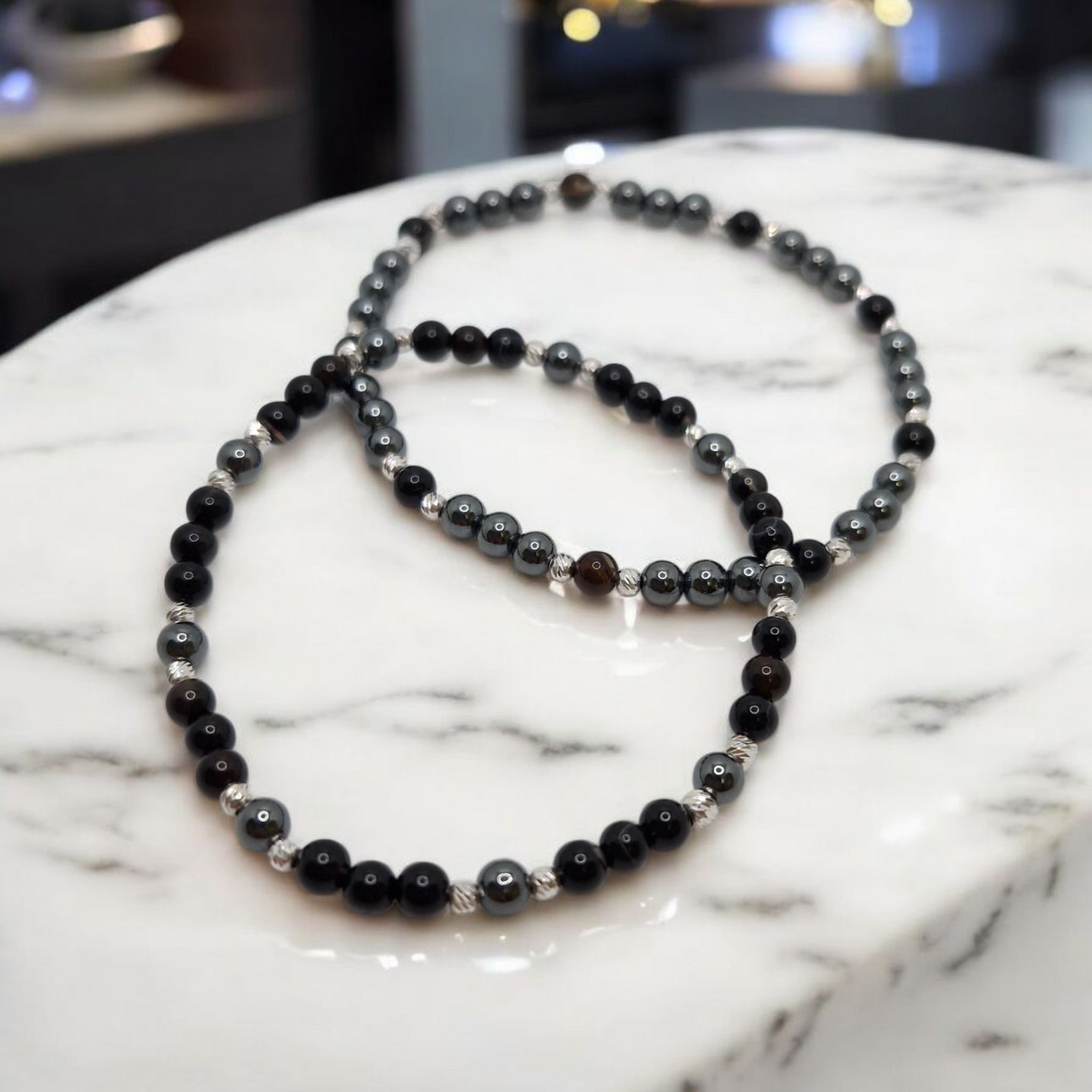Black beaded necklace on a marble surface
