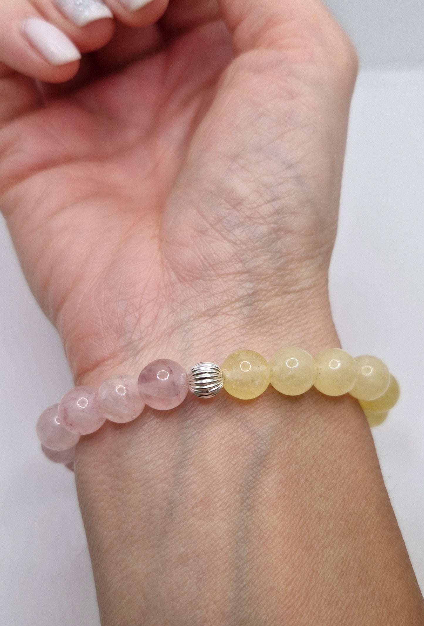 Beaded bracelet on a wrist with a plain background