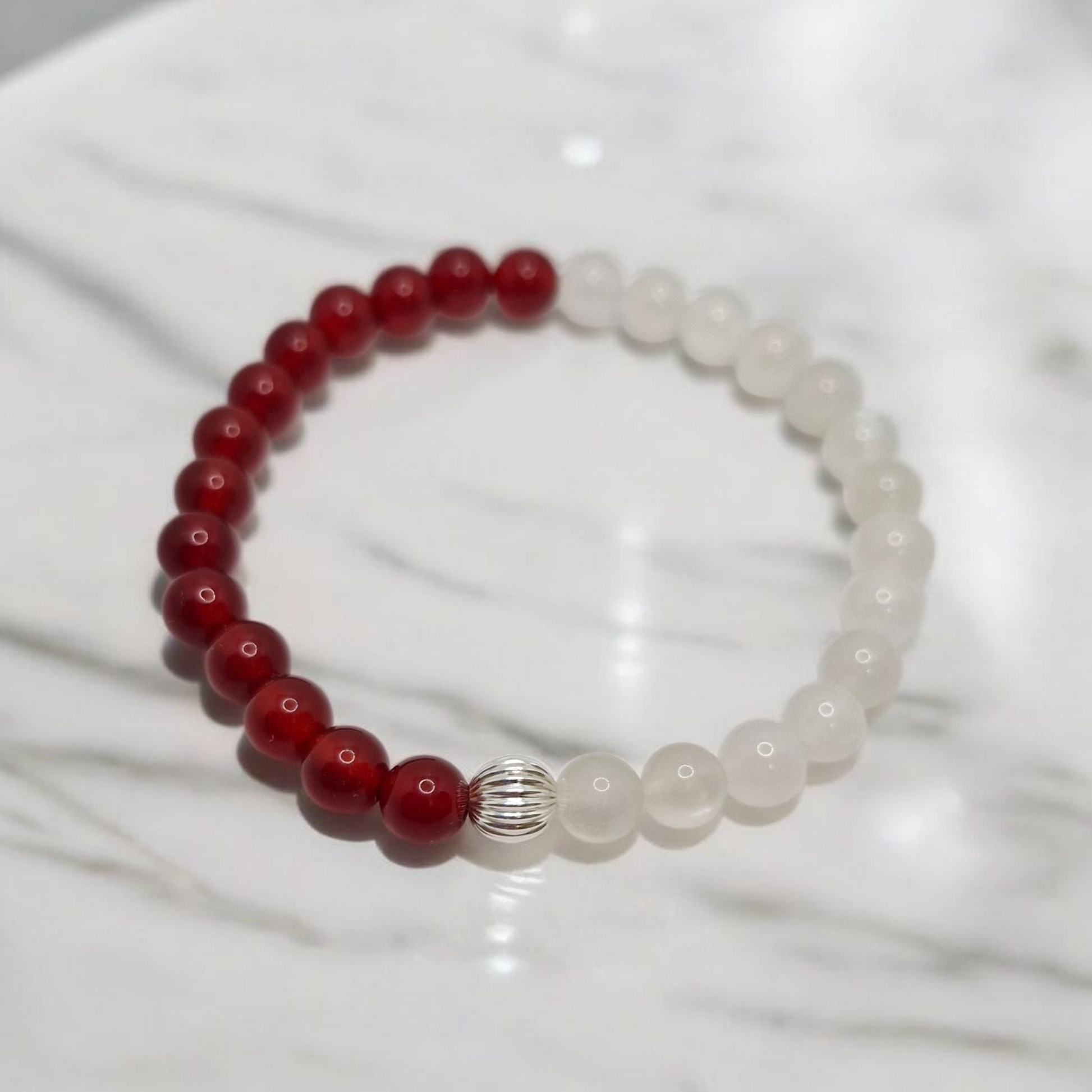 Beaded bracelet with red and white beads on a white background