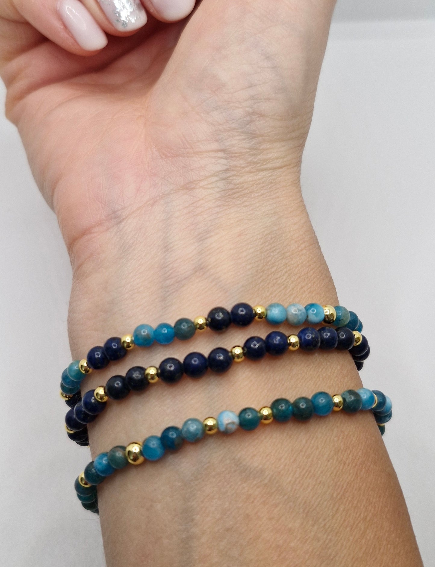 Beaded bracelets on a wrist against a white background