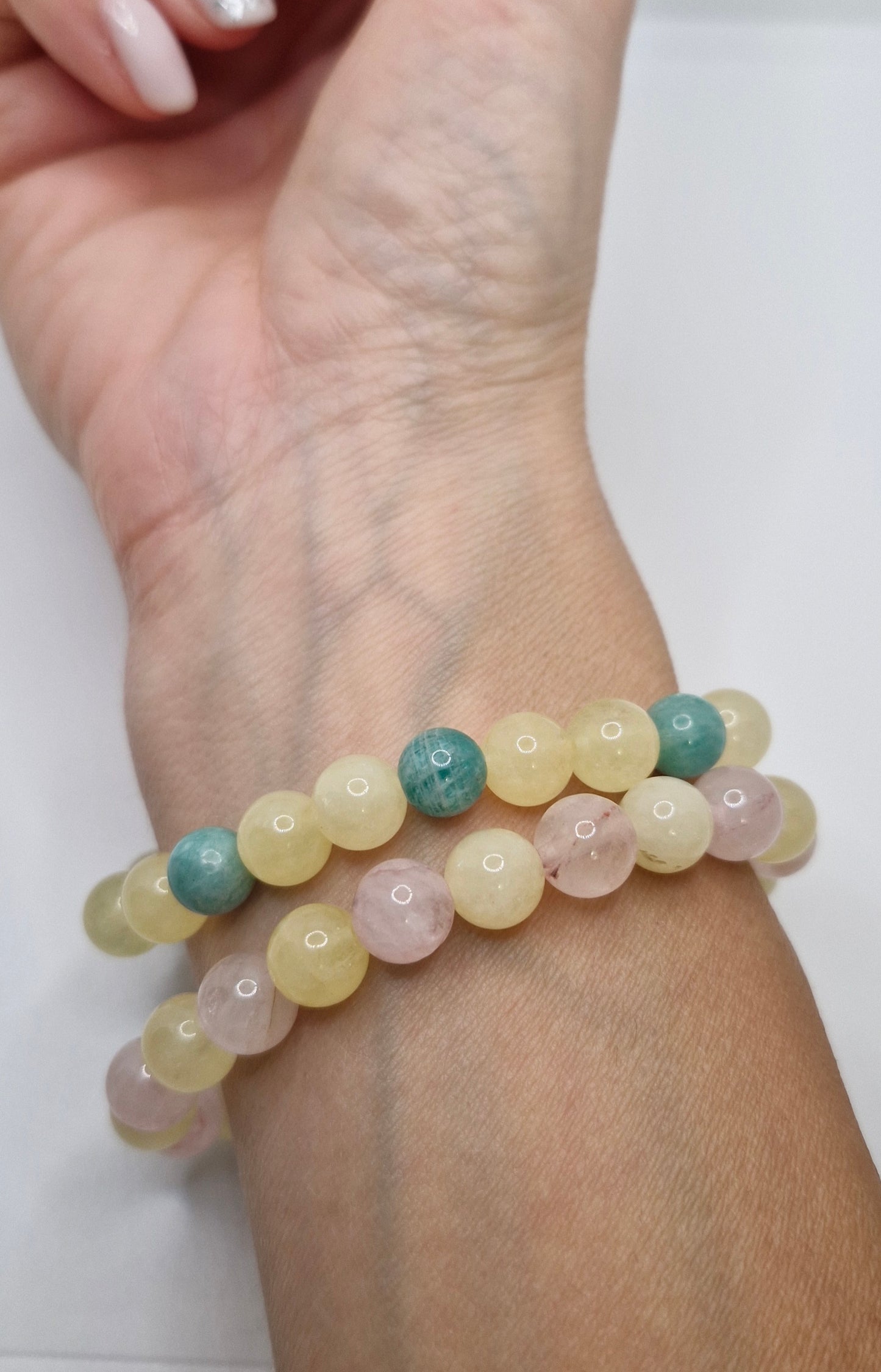 Multicolored beaded bracelet on a wrist with a white background