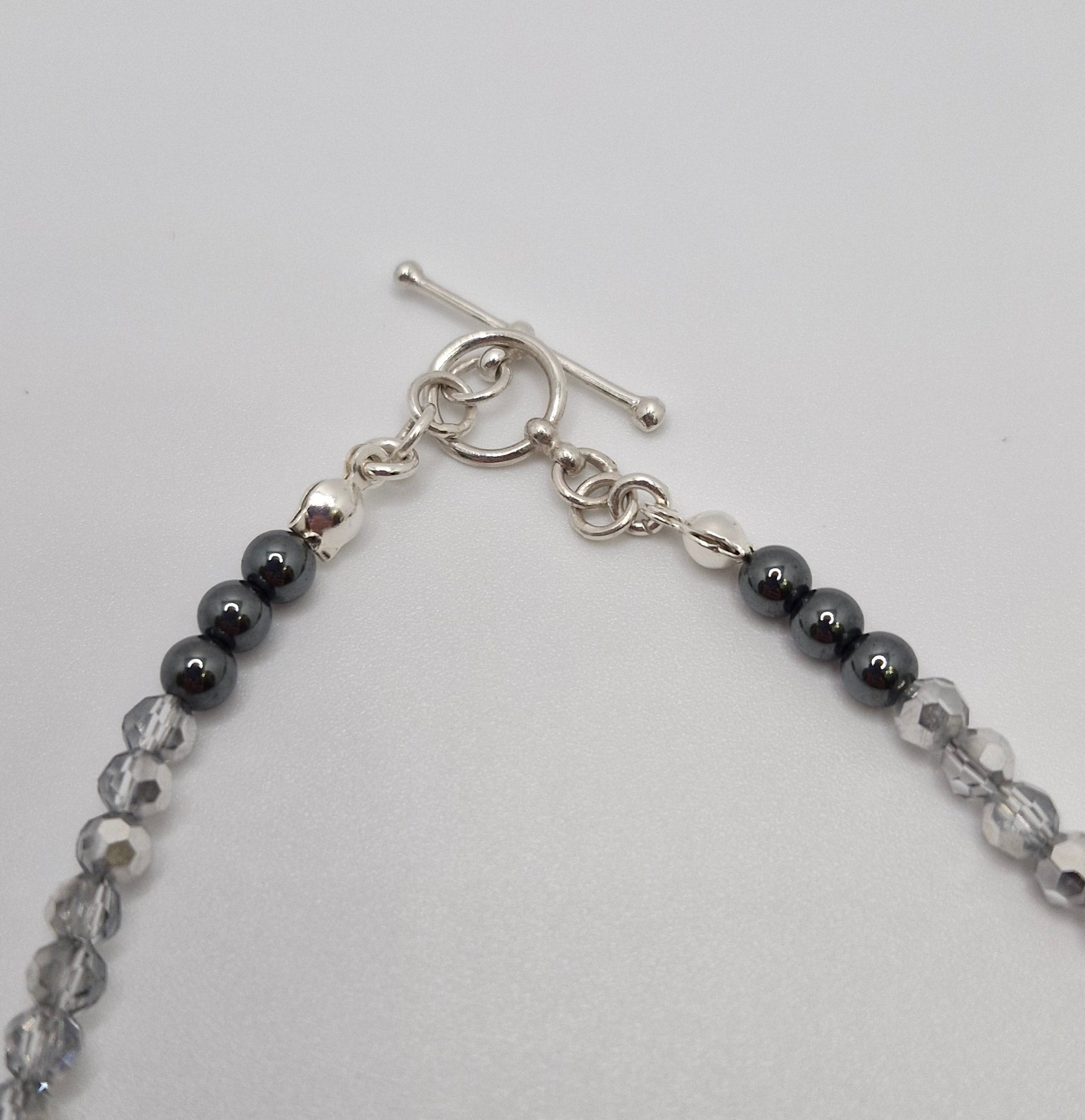 Beaded necklace with silver clasp on a light gray background