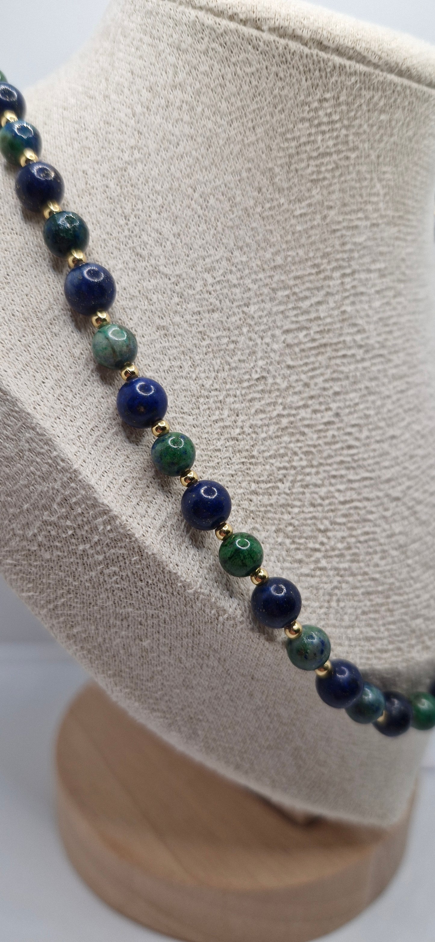 Necklace with blue and green beads on a mannequin head