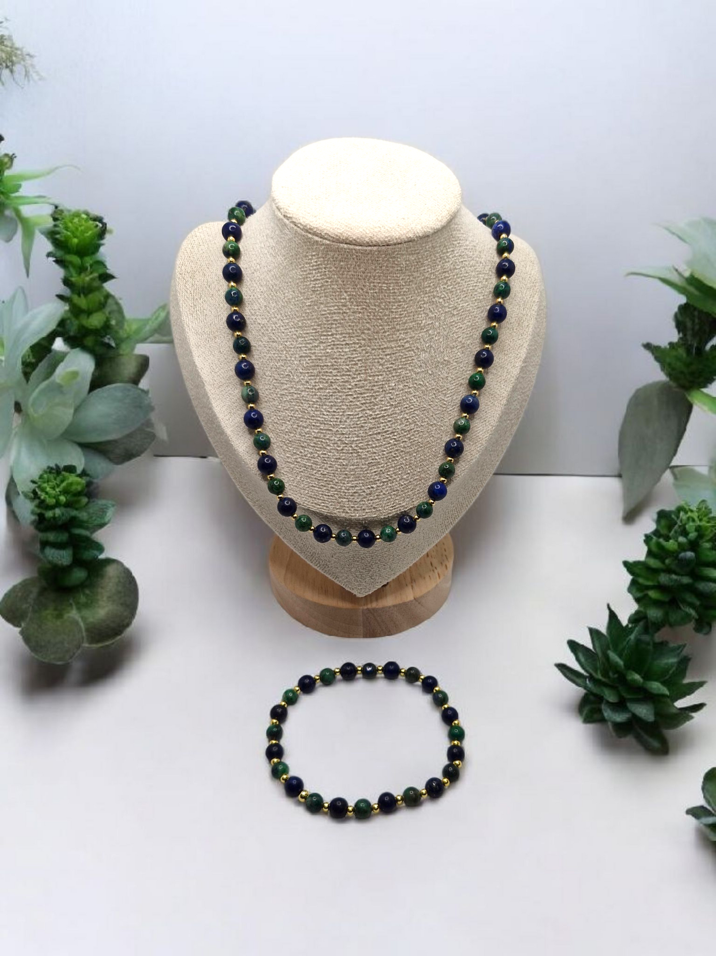 Necklace and bracelet set on a mannequin bust with succulents in the background