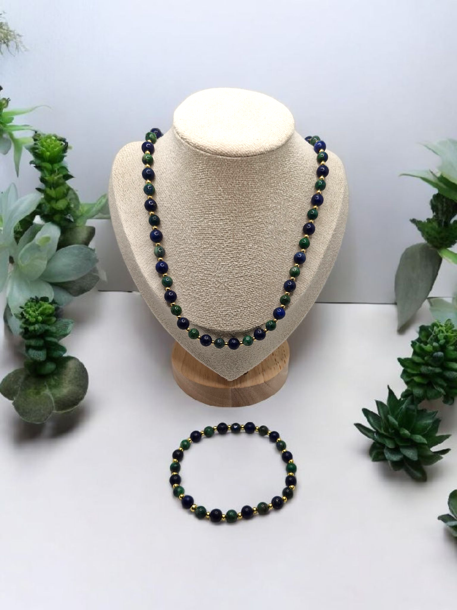 Necklace and bracelet set on a mannequin bust with succulents in the background