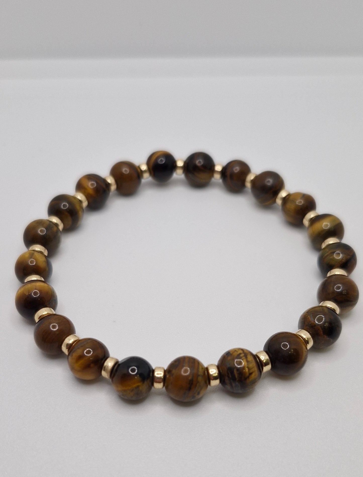 Beaded bracelet with brown and gold beads on a white background