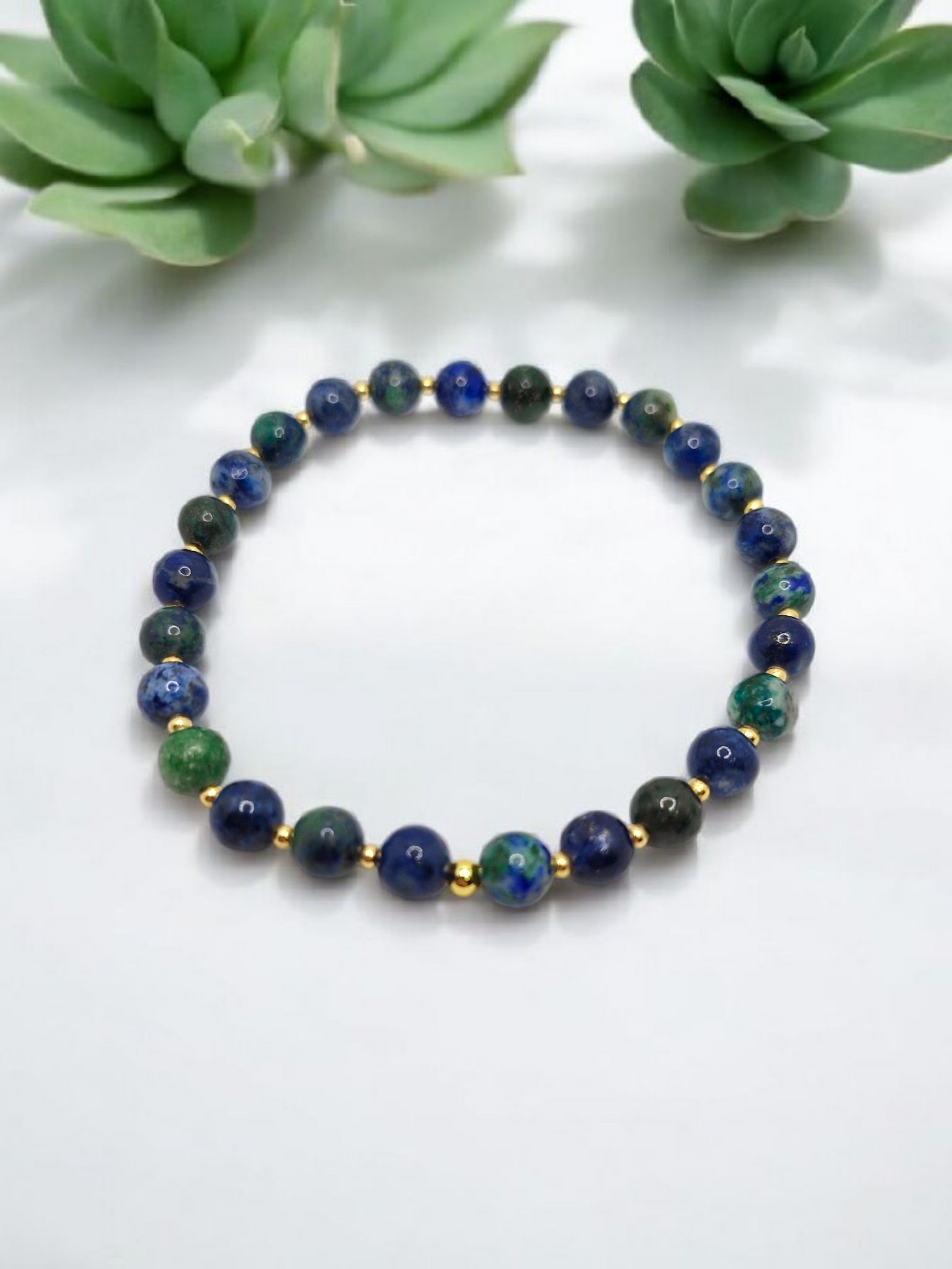 Beaded bracelet with blue and green stones on a white background