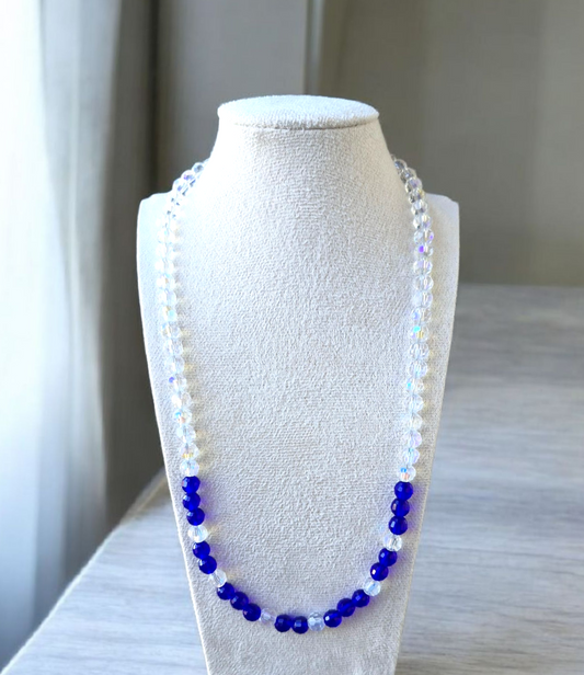 Necklace with blue and white beads on a mannequin bust against a neutral background