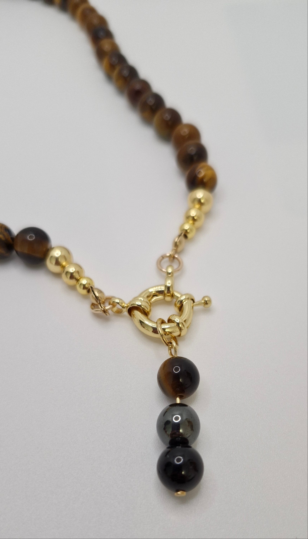 Elegant gemstone necklace promoting protection, courage, and balance with Tiger Eye and hematite accents