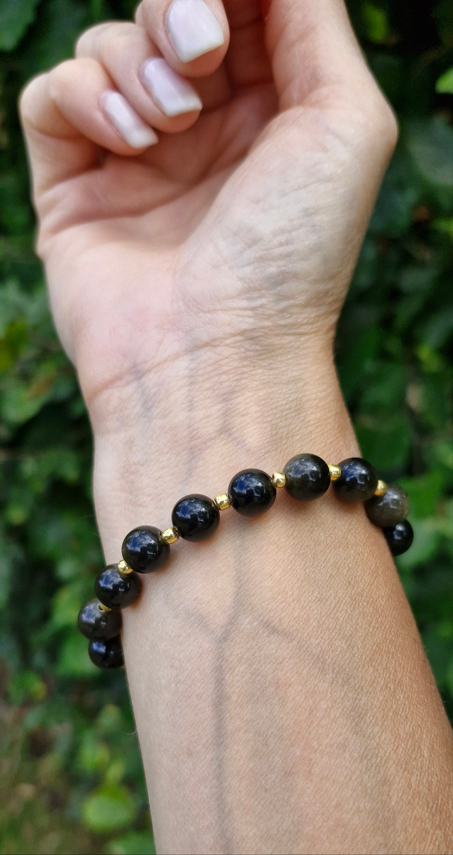 Golden Obsidian stretch bracelet styled on wrist with elegant black and gold beaded design