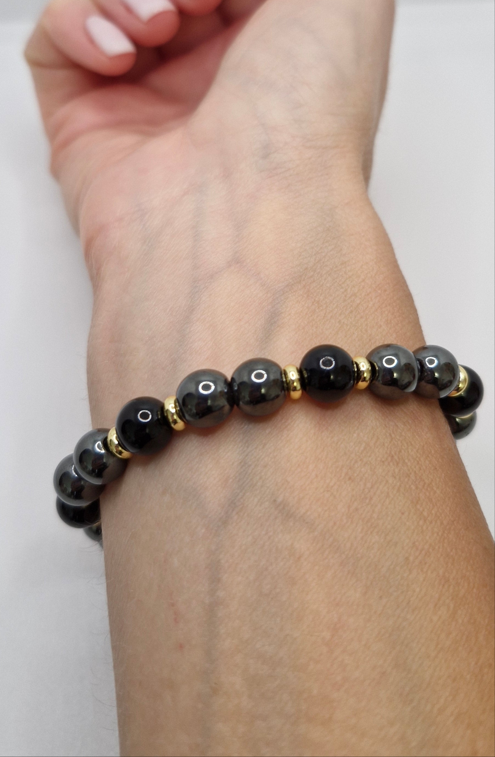 Protective crystal bracelet combining 8mm Black Tourmaline and Hematite beads with golden detail