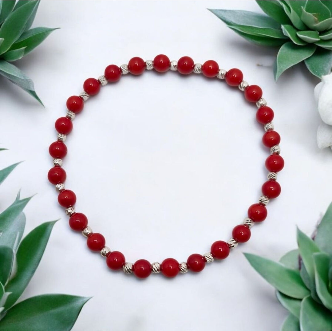Red Coral dyed gemstone bracelet with faceted stretch design and sterling silver accents.