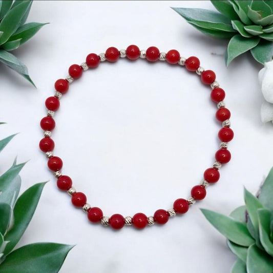 Red Coral dyed gemstone bracelet with faceted stretch design and sterling silver accents.