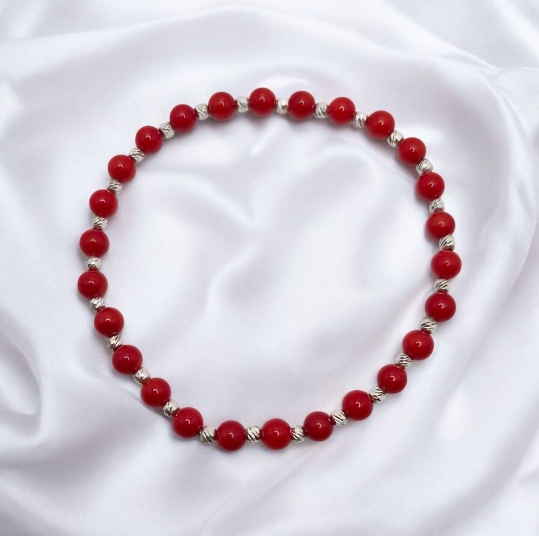 Red Coral dyed gemstone bracelet with faceted stretch design and sterling silver accents.