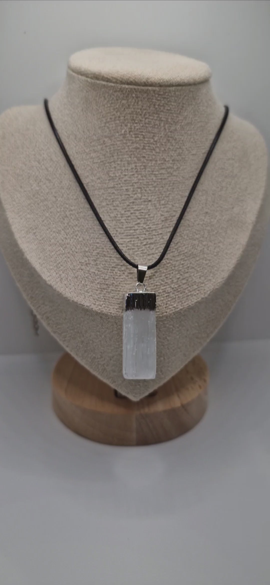 Video showing a handmade rectangular Selenite pendant on a black 1.5mm rope necklace, highlighting natural crystal texture and smooth finish.
