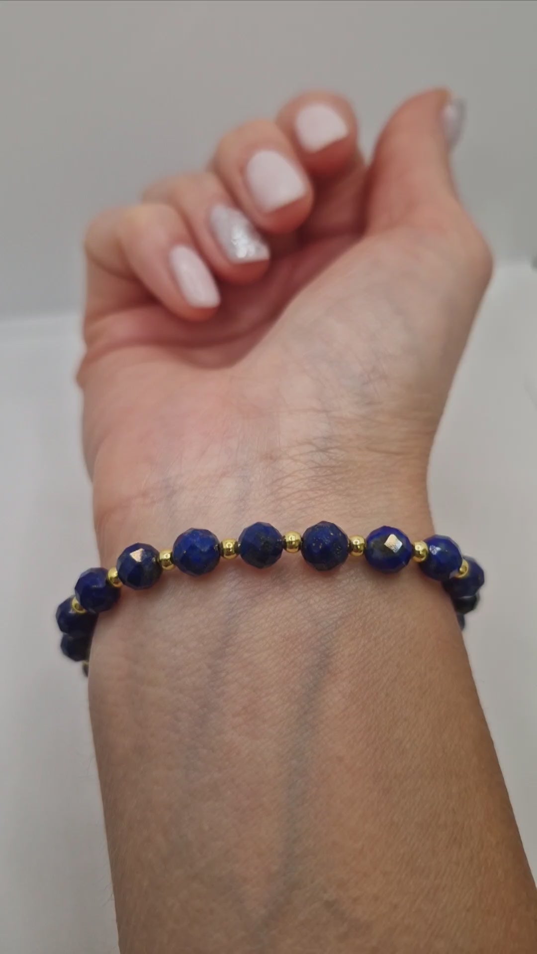Video showing wearing stretch Lapis Lazuli faceted bracelet with gold accents 