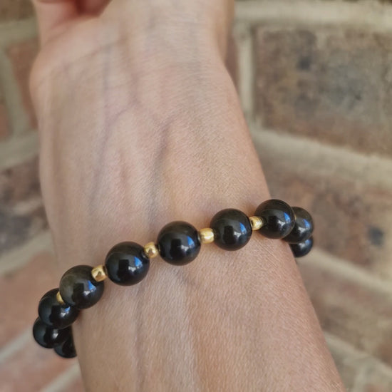 Video of Golden Obsidian stretch bracelet with 8mm gemstone beads and gold Toho accents, handmade crystal healing jewellery.